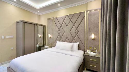 a bedroom with a large white bed in a room at كريستال الخليج للشقق الفندقيه in Kuwait