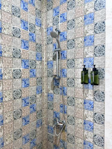 a bathroom with a shower with blue and white tiles at كريستال الخليج للشقق الفندقيه in Kuwait