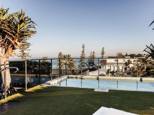 a swimming pool with a view of the ocean at The Sebel Brisbane Margate Beach in Redcliffe
