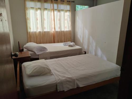two beds in a room with a window at Indiana Lodge in Santa Clara