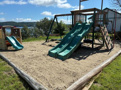 a playground with a slide in the sand at Pimishka Chalet-Cottage-Studios in Bouchette