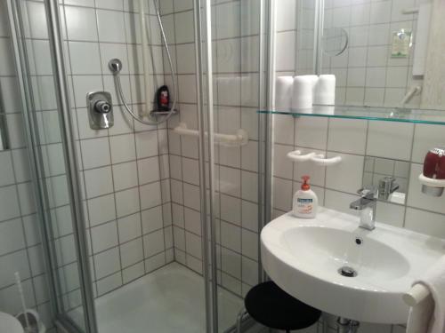 a bathroom with a shower and a sink at Hotel Garni Sand in Tübingen