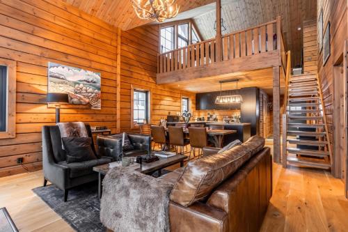 a living room with leather furniture and a wooden wall at Idre Luxury Chalet Winter Haven /w Sauna - Happy Rentals in Idre