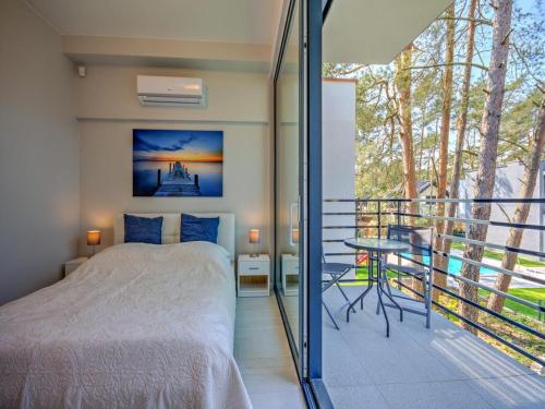 a bedroom with a bed and a balcony at Comfortable holiday home with a garden and a pool in Pobierowo
