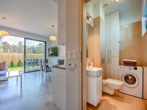 a bathroom with a washer and dryer in a house at Comfortable holiday home with a garden and a pool in Pobierowo