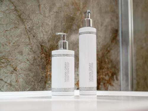 two bottles ofodorizers sitting on a counter in front of a mirror at Holiday studio with balcony, indoor pool, sauna in Polanica-Zdrój