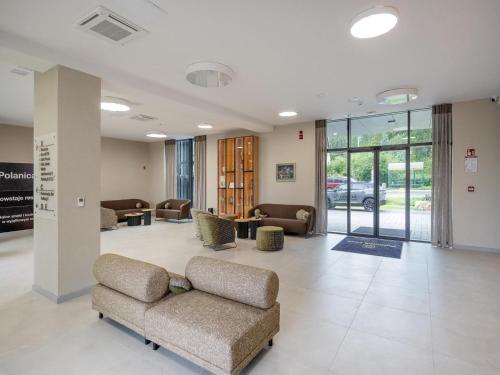 a lobby with couches and chairs in a building at Holiday studio with balcony, indoor pool, sauna in Polanica-Zdrój