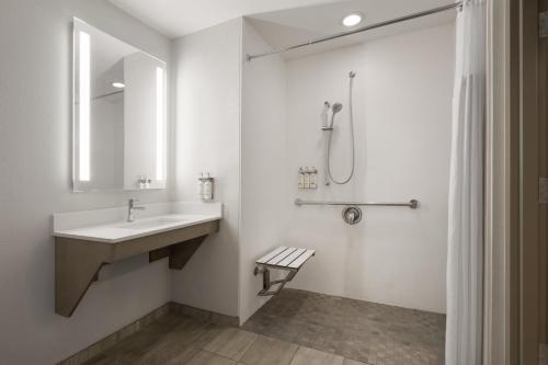 a white bathroom with a sink and a shower at Holiday Inn Express Pembroke by IHG in Pembroke