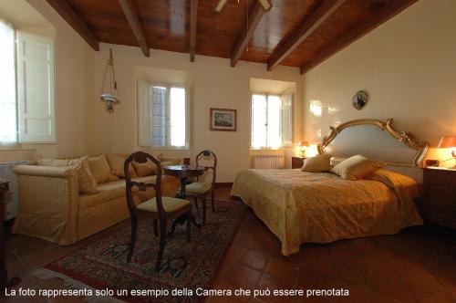 a bedroom with a bed and a couch and a table at B&B Villa Dei Priori in Monsampolo del Tronto