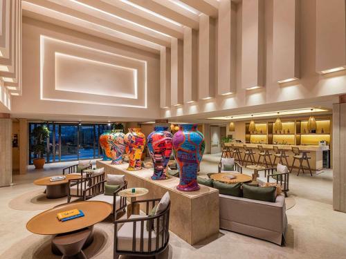 a lobby with tables and chairs and vases on display at The Bodrum Hotel Yalıkavak - MGallery Collection in Yalıkavak