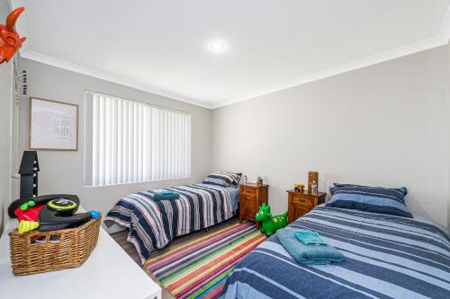 a bedroom with two beds and a window at Waves And Moore - Beautifully presented home in Guilderton