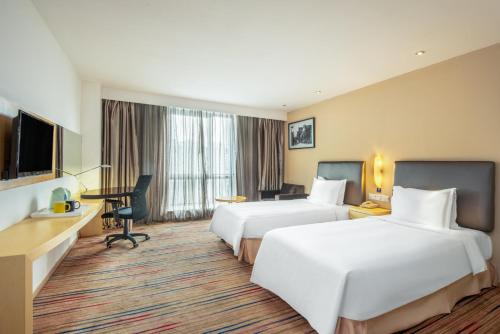 a hotel room with two beds and a desk at Holiday Inn Express Changzhou Centre by IHG in Changzhou