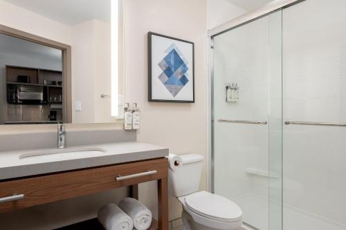 a bathroom with a toilet and a glass shower at Candlewood Suites Mooresville Lake Norman,NC by IHG in Mooresville