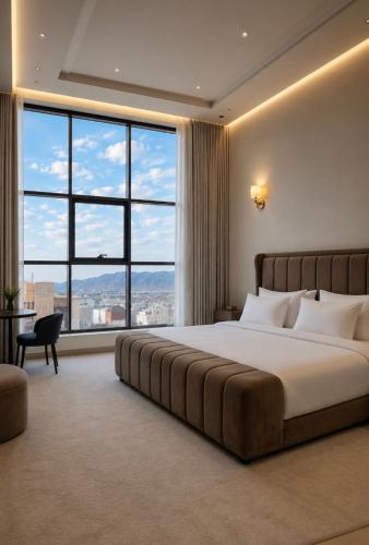 a bedroom with a large bed and large windows at O2P Al Salam in Medina
