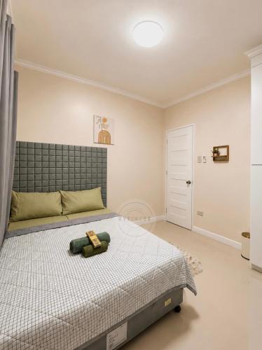 a bedroom with a bed with a teddy bear on it at Cozy Home in Dipolog by Aveinz in Dipolog