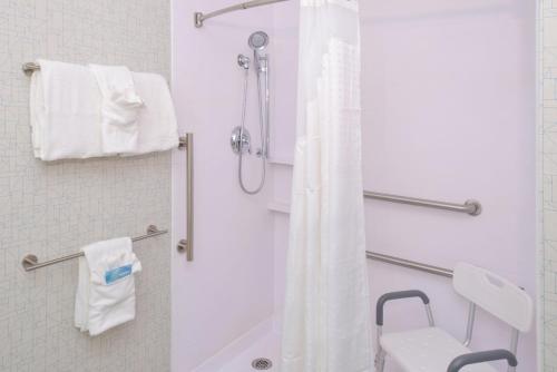 a bathroom with a shower with a white shower curtain at Holiday Inn Express & Suites - Omaha - 120th and Maple by IHG in Omaha