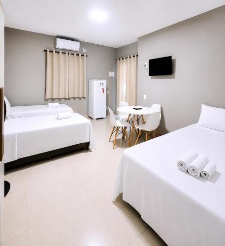 a bedroom with two beds and a table with a tv at Mar & Sol Preá - 700m da Praia - 12km de Jeri - 15km do Aeroporto in Prea