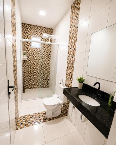 a bathroom with a shower and a toilet and a sink at Mar & Sol Preá - 700m da Praia - 12km de Jeri - 15km do Aeroporto in Prea