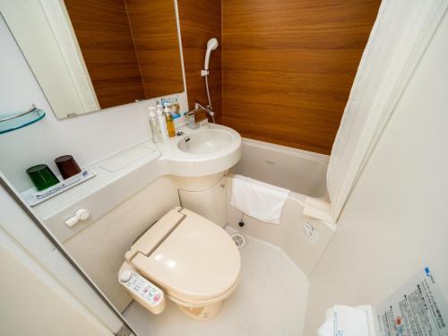 a small bathroom with a toilet and a sink at Super Hotel Yokkaichi Route 1 in Yokkaichi
