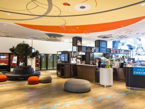 a restaurant with a bar with a person in the background at Novotel Milano Linate Aeroporto in Milan