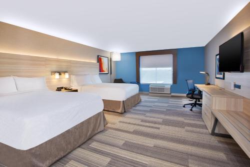a hotel room with two beds and a flat screen tv at Holiday Inn Express & Suites Wooster by IHG in Wooster