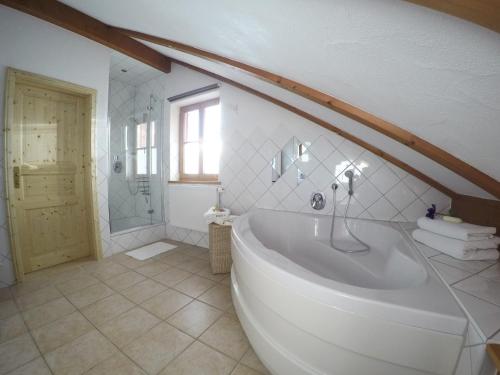 ein Badezimmer mit einer großen Badewanne und einer Dusche in der Unterkunft Ferienwohnung Sandra Wetzel in Waltenhofen