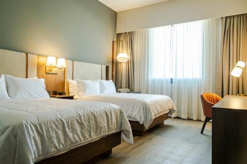 a hotel room with two beds and a window at Holiday Inn Navojoa by IHG in Navojoa