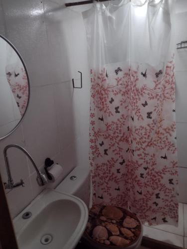 a bathroom with a sink and a shower curtain with bats at Casa lai in Rio de Janeiro
