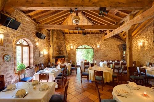 a dining room with tables and chairs and a fireplace at El Señorio De La Serrezuela in Aldeanueva De La Serrezuela 