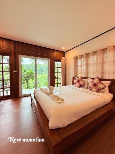 a large bed in a bedroom with a large window at Mangrove bungalow & restaurant in Ko Kood