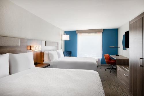 a hotel room with two beds and a desk at Holiday Inn Express Wilson I-95 by IHG in Wilson