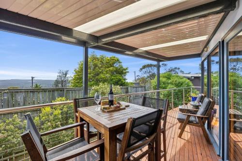 a patio with a wooden table and chairs on a deck at Blue Water - BYO Linen in Anglesea