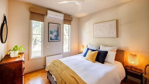 a bedroom with a bed with blue and yellow pillows at Kyarra in Aireys Inlet