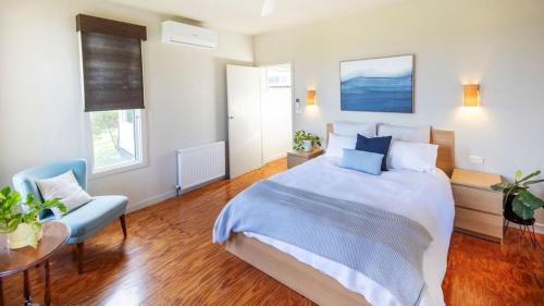a bedroom with a large bed and a table at Kyarra in Aireys Inlet