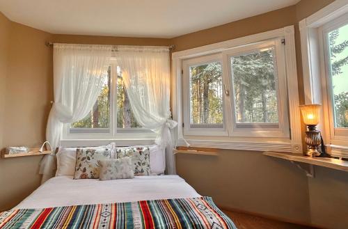 a bedroom with a bed and two windows at Shambhala Retreat-Zen Suite in Nanoose Bay
