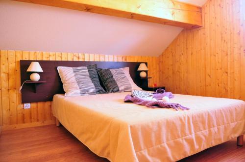 um quarto com uma cama com um urso de peluche em Résidence Goélia Les Chalets des Ecourts em Saint-Jean-dʼArves