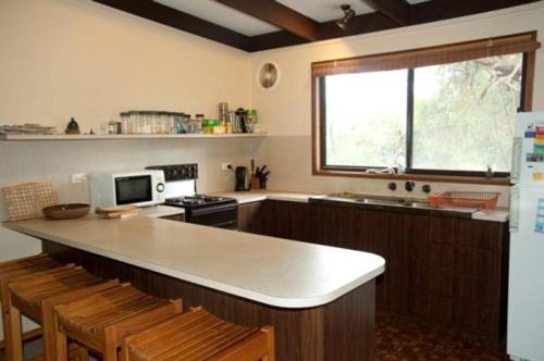 a kitchen with a counter and a sink and a microwave at 40 Aireys Street in Aireys Inlet