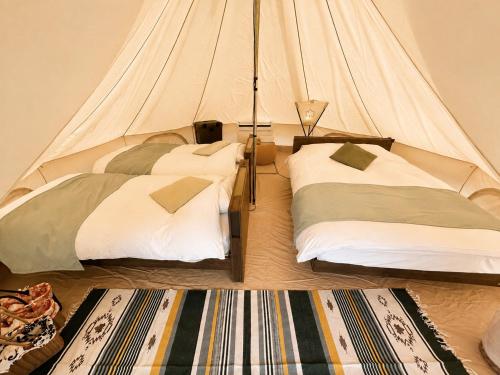 a bedroom with two beds in a tent at 瀬戸内リゾートベッセルおおち in Higashikagawa