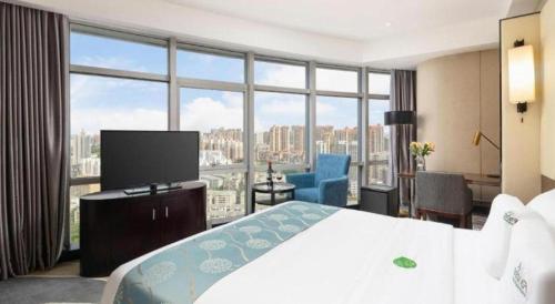 a hotel room with a bed and a large window at Nanning Champs Elysees Hotel in Nanning