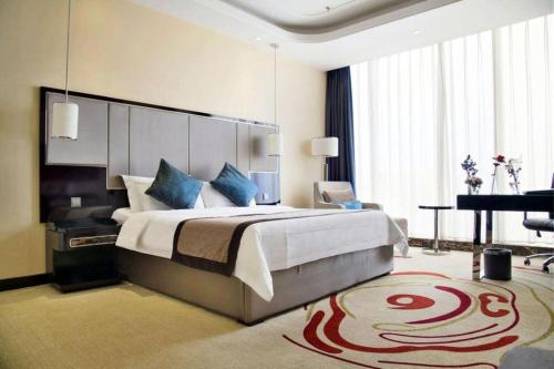 a bedroom with a large bed and a grand piano at Pacific Regency Hotel Shenyang in Shenyang