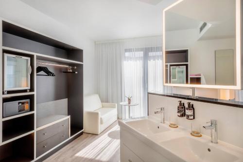 a bathroom with a white sink and a mirror at INNSiDE by Meliá Frankfurt Ostend in Frankfurt