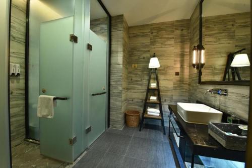 a bathroom with a sink and a mirror and a ladder at MAIHAOHOTELS in Huangdong