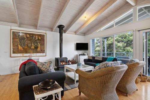 a living room with a couch and chairs and a fireplace at Coastwalk in Aireys Inlet