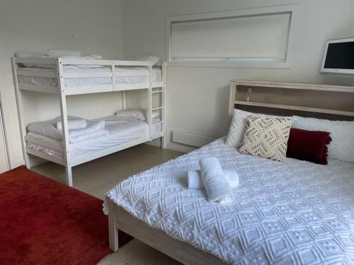 a bedroom with a bed and a bunk bed at Drift - Luxury, location and ocean views in Wye River