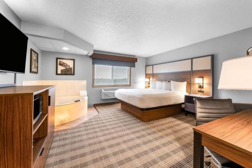 a hotel room with a bed and a flat screen tv at AmericInn by Wyndham Sauk Centre in Sauk Centre