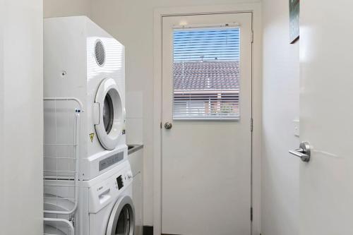 a laundry room with a washing machine and a window at Merihaven in Apollo Bay