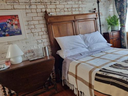 a bedroom with a bed and a table with a lamp at Room at Lindley in Ludlow