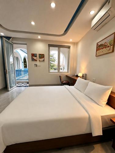 a large white bed in a room with a window at Lêu Hêu Villa & Coffee in Thôn Mỹ Phước