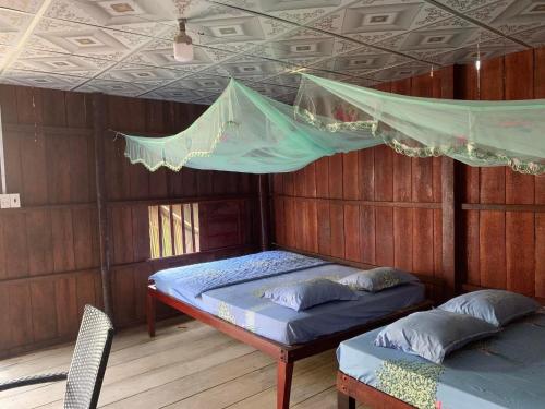 a room with a bed and a hammock in it at Nam Binh Homestay in Ben Tre
