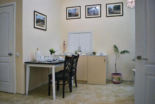 a kitchen with a table and chairs in a room at Classic Apartment on Zhukovskoho in Odesa